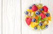 Fresh fruit salad on a light wooden table background