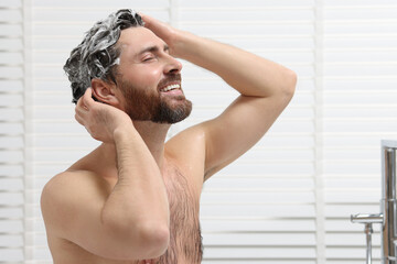 Poster - Happy man washing his hair with shampoo in shower