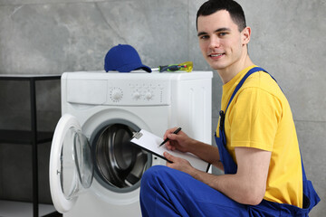 Sticker - Smiling plumber writing results of examining washing machine in bathroom