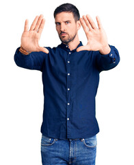 Poster - Young handsome man wearing casual shirt doing frame using hands palms and fingers, camera perspective