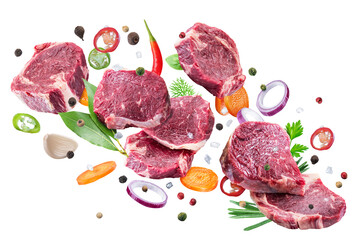 Poster - Raw beef steaks, herbs and pieces of vegetables levitating in air on white background. File contains clipping path.