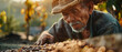 Sunlight bathes an old farmer carefully picking coffee beans, immersed in his harvest ritual.