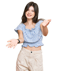 Sticker - Young beautiful caucasian girl wearing casual clothes smiling cheerful offering hands giving assistance and acceptance.