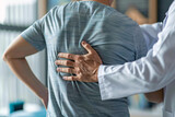 Fototapeta Panele - Physiotherapist assessing man with back pain in clinic