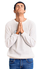 Wall Mural - Young african amercian man wearing casual clothes begging and praying with hands together with hope expression on face very emotional and worried. begging.