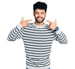 © Krakenimages.com - Young arab man with beard wearing casual striped sweater smiling cheerful showing and pointing with fingers teeth and mouth. dental health concept.