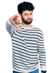 Wall Mural - Young arab man with beard wearing casual striped sweater looking unhappy and angry showing rejection and negative with thumbs down gesture. bad expression.