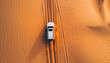 car moves through deep sand in the desert top view