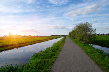 Canvas Print - Landscape green meadow and canal with clear water