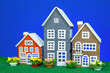 Three colorful toy houses on a blue background