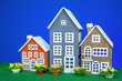 Three colorful toy houses with flowers nearby