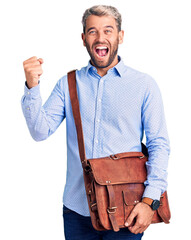 Wall Mural - Young handsome blond man wearing elegant shirt holding briefcase screaming proud, celebrating victory and success very excited with raised arms