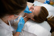 Cosmetologist administering injection in face of client during rejuvenation treatment in hospital