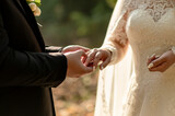Fototapeta Boho - The groom puts a wedding ring on the bride's finger	