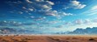 Desert landscape with blue sky and white clouds.