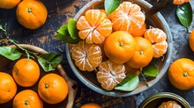 Juicy Tangerines And Oranges In A White Bowl With Green Leaves