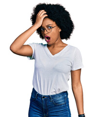 Wall Mural - Young african american woman wearing casual white t shirt surprised with hand on head for mistake, remember error. forgot, bad memory concept.