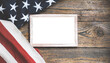 Blank White frame mockup design. American flag on a rustic wooden background. USA Memorial day, Veterans day, Labor day, or 4th of July celebration. Copy space, minimalistic illustration.