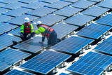 Fototapeta  - Engineers in safety gear inspect solar panels at a renewable energy farm, ensuring sustainable power efficiency