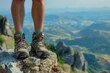 Close-up of hiker's boots on a mountain peak with valley view.