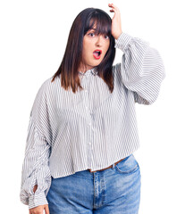 Canvas Print - Young plus size woman wearing casual clothes surprised with hand on head for mistake, remember error. forgot, bad memory concept.