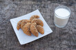 Freshly baked cookies on plate with glass of milk.