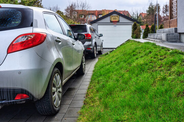 Free-standing garage in the garden with cars parked in front of the gate