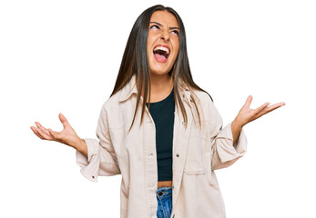 Wall Mural - Beautiful hispanic woman wearing casual clothes crazy and mad shouting and yelling with aggressive expression and arms raised. frustration concept.