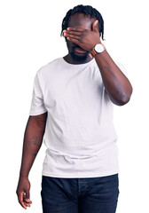 Poster - Young african american man with braids wearing casual white tshirt covering eyes with hand, looking serious and sad. sightless, hiding and rejection concept