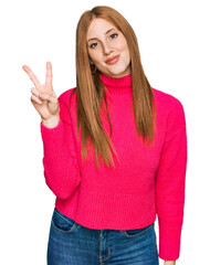 Wall Mural - Young irish woman wearing casual clothes showing and pointing up with fingers number two while smiling confident and happy.