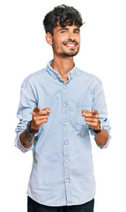 Wall Mural - Young hispanic man wearing casual clothes pointing fingers to camera with happy and funny face. good energy and vibes.