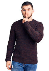 Sticker - Young handsome man wearing casual sweater asking to be quiet with finger on lips. silence and secret concept.