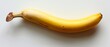   A banana sits on a white surface with two brown spots, one at each end