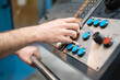© herraez - Worker pressing buttons on CNC machine control board in factory. High quality photography.