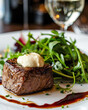 Filet Tenderloin alongside arugula salad with white  sauce cream on top, fancy Italian restaurant blurry background