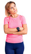 Young blonde woman wearing sportswear looking to the side with arms crossed convinced and confident