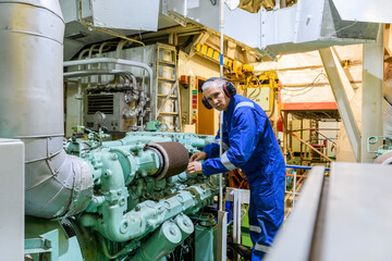 Wall Mural - Marine Engineer in blue overall working in Engine room of ship. Work at sea. Motorman.