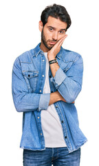 Wall Mural - Young hispanic man wearing casual clothes thinking looking tired and bored with depression problems with crossed arms.