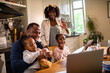 © Marko Geber - Young family having a video call on their laptop while having breakfast at home in the morning
