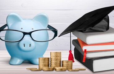 Wall Mural - Graduation hat on piggy bank with coins