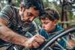 A man and a boy are fixing a bicycle tire