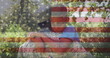 Image of male soldier embracing son over american flag