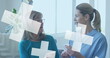 Image of crosses over caucasian female doctor and senior patient talking
