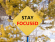 © Dzmitry - Stay focused symbol. Concept words Stay focused on beautiful yellow road sign. Beautiful forest snow blue sky background. Business, support, motivation, psychological stay focused concept. Copy space