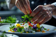 a chef's hands meticulously garnishing a gourmet dish with edible flowers and microgreens, transforming it into a work of culinary art