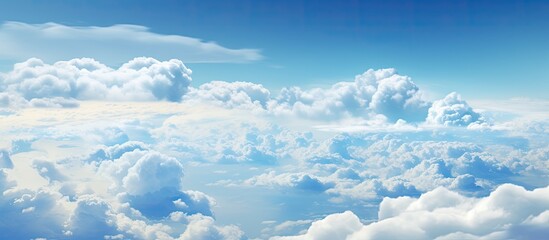 Wall Mural - the view from the airplane reveals a cloudy sky with cumulus clouds against an electric blue horizon