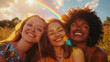 Diverse group of happy female friends of different races & ethnicies smiling outdoors in nature on sunny summer day with rainbow in the sky. Women celebrating  pride month. LGBTQ+ gen z concept. 