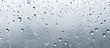 © TheWaterMeloonProjec - A close up of water droplets on a window, created by the atmospheric event of drizzle. The grey liquid reflects the moisture of the precipitation