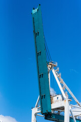 Wall Mural - Gantry crane arm on the blue sky background. Container terminal of Miami sea port.