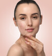 © New Africa - Woman with acne on her face on beige gradient background. Zoomed area showing problem skin